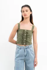 Conjunto de top corto y falda corta color verde agua. El top es de breteles anchos, corte recto y con volados verticales y botones decorativos en el frente. La falda es de corte recto con volados en el ruedo.