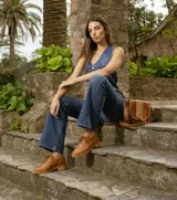 Zapato acordonado estilo oxford de cuero vacuno color suela, con detalles de perforaciones decorativas tipo brogue, cordones al tono y suela de goma con taco bajo de madera.