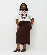 Pollera midi de corte recto, confeccionada en sarga de algodón con textura cotelé. Presenta cintura media, cierre frontal con botón y cremallera, bolsillos funcionales y una abertura trasera para mayor comodidad.