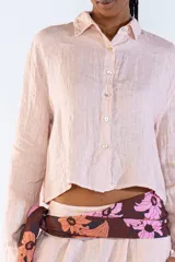 Camisa de lino 100% italiano, color rosado, de corte cropped, manga larga y cierre frontal con botones.