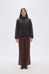 Campera puffer negra de nylon con diseño acolchado, cierre frontal y capucha integrada.