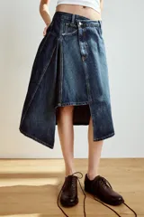 Falda midi de denim azul con tiro medio, diseño asimétrico de bajo cruzado y cinco bolsillos clásicos.