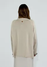 Sweater azul con diseño de flor en el frente y detalles de volados en puños y ruedo.