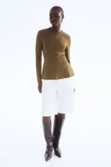 Top de manga larga en tejido de punto con diseño peplum, cuello redondo y costuras moldeadoras en el frente y la espalda.