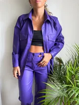 Camisa lila con textura de cocodrilo, de corte recto, manga larga y bolsillos frontales.