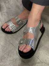 Sandalias plateadas con hebillas y suela track negra.