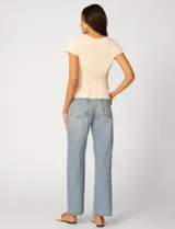 Remera blanca de manga corta con cuello redondo, confeccionada en una mezcla de modal, poliéster y elastano. Presenta un diseño con alforzas verticales en el frente que aportan estructura y una silueta relajada.