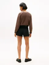 Short de denim negro de tiro alto, con corte mini flare y detalles de costura en contraste. Presenta cierre de botón y cremallera, diseño de 4 bolsillos y logo bordado de Tommy Hilfiger en el bolsillo trasero.