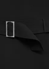 Vestido corto de cuello alto y sin mangas, confeccionado en tejido fluido. Presenta un diseño entallado con cinturón decorativo a la cintura y cierre de cremallera en la parte posterior.