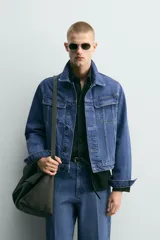 Cazadora de denim de algodón con corte relajado, cuello solapa, cierre frontal de botones y mangas largas con puños abotonados. Presenta bolsillos de solapa en el pecho y bolsillos laterales de vivo, con un acabado de efecto lavado.