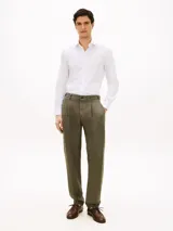 Camisa blanca de corte slim, confeccionada en sarga de mezcla de algodón elástico, con cuello italiano, mangas largas con puño y cierre frontal de botones.
