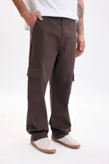 Pantalón cargo baggy color marrón, de corte holgado, con múltiples bolsillos utilitarios en los laterales y cierre frontal.