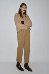 Pantalón de tiro medio con pinzas delanteras y pernera recta. Cuenta con bolsillos frontales, falsos bolsillos traseros de vivo y cierre frontal con cremallera, botón interior y ganchos.