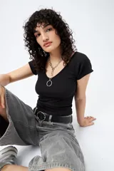 Remera gris de ribb con escote en V, mangas cortas con dobladillo, corte cropped y textura canelada.