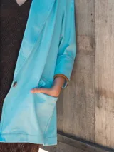 Blazer celeste de corte recto con solapas y bolsillos delanteros.