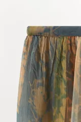 Pantalón de tiro bajo con cintura elástica, confeccionado en tejido de viscosa semitransparente con diseño drapeado y aberturas laterales en las piernas.