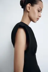 Vestido midi de Zara Woman Collection confeccionado en popelín de algodón. Presenta cuello redondo, manga corta y detalle de pliegues en la cintura que dan paso a una falda con caída evasé. Cierre posterior con abertura y botón.