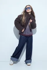 Campera puffer de corderito negro con cuello alto y diseño oversized. Presenta una textura tipo teddy, cierre frontal y corte a la cintura.