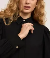 Camisa celeste de crepé con cuello inglés, manga larga abullonada y abotonadura frontal.