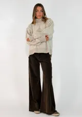 Sweater de punto color azul marino, con cuello alto, diseño de rombos en relieve y detalle de flecos en las mangas.