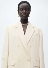 Chaqueta tipo blazer de corte recto y diseño cruzado con cierre de botones. Presenta cuello con solapas de muesca, manga larga con puños abotonados y bolsillos delanteros con solapa.