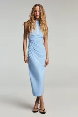 Vestido midi de cuello subido y sin mangas, confeccionado con un diseño drapeado lateral que aporta textura y movimiento a la prenda. Presenta un corte entallado y cierre de cremallera oculta en la espalda.
