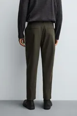 Pantalón regular fit color azul marino, confeccionado en tejido elástico. Cuenta con bolsillos frontales, bolsillos traseros de vivo con botón y cierre frontal con cremallera y botón.