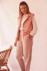 Pantalón de vestir color beige, con pinzas, bolsillos laterales y cierre frontal.