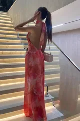 Vestido largo con estampado abstracto en tonos rosados y naranjas, diseño de cuello halter y espalda descubierta.