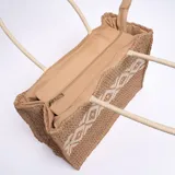 Bolso de yute color marrón claro con diseño geométrico en blanco y doble asa de mano.