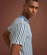 Polo de punto de manga corta para hombre, con cuello estilo cubano (sin botones) y patrón de rayas verticales en tonos azul marino, blanco y gris claro.