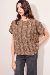 Blusa color beige con estampado animal print en marrón, de corte holgado y mangas cortas.