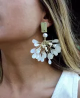 Aros colgantes dorados con perlas y pétalos blancos.