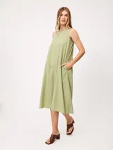 Vestido midi sin mangas color verde, de corte amplio y relajado, con cuello redondo y bolsillos laterales.