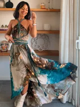 Vestido largo verde con diseño estampado tipo tie-dye y detalles dorados, de corte fluido, un solo hombro y diseño amplio.