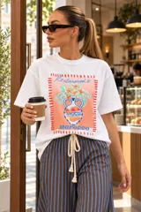 Remerón blanco de corte holgado con estampa frontal colorida y texto "Champagne & Oysters".