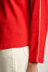 Sweater rojo de algodón con textura y corte oversize. Tiene mangas largas con dos rayas blancas en los brazos.