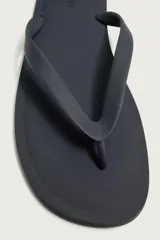 Sandalia de goma color negro, de diseño plano y tiras delgadas en el empeine estilo ojota.