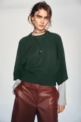 Jersey de punto liso color bordó, con cuello redondo y mangas anchas de largo tres cuartos. Presenta acabados en rib en cuello, puños y ruedo.