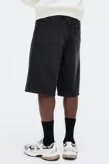 Bermuda de cinco bolsillos en denim de algodón rígido, con corte holgado tipo baggy, tiro caído y pierna amplia.