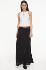 Falda larga de tejido artesanal negro, con diseño fluido y detalles calados.