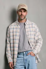 Camisa de manga larga con estampado a cuadros en tonos crudo, celeste y beige, de corte relajado y con un bolsillo en el pecho.