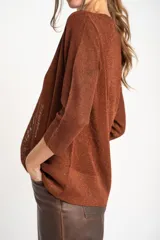 Sweater de punto con acabado brillante, cuello en V y mangas tres cuartos. Presenta un diseño holgado y tejido traslúcido.
