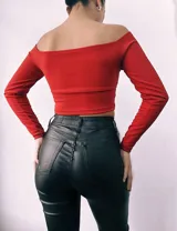 Top corto color terracota, con escote cruzado tipo "off-shoulder" y mangas largas.