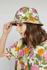 Gorro tipo bucket reversible con estampado floral en tonos rosa, amarillo y verde de un lado, y verde militar liso del otro.
