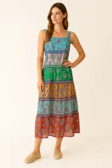 Vestido largo con estampado de cachemir en tonos azul, verde, naranja y rojo. Presenta cuello cuadrado, breteles anchos y corte evasé con elástico en el pecho.