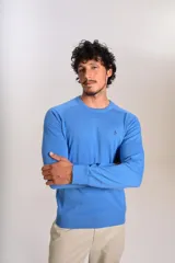 Sweater de punto de algodón en color azul, con cuello redondo, mangas largas con puños acanalados y logo de la marca bordado en el pecho.