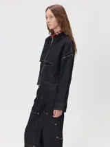 Campera de denim a rayas verticales con cuello de pana en color bordó. Presenta cierre frontal, mangas desmontables con cierre en los hombros, canesú en el pecho y bolsillos de parche cuadrados.