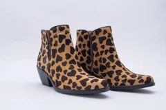 Texana de caña corta con diseño de animal print en color fucsia y negro. Presenta un taco bajo y aberturas laterales.