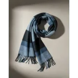 Bufanda rectangular de tejido grueso con diseño de cuadros en tonos azul, naranja, gris y beige, terminada con flecos en los extremos.